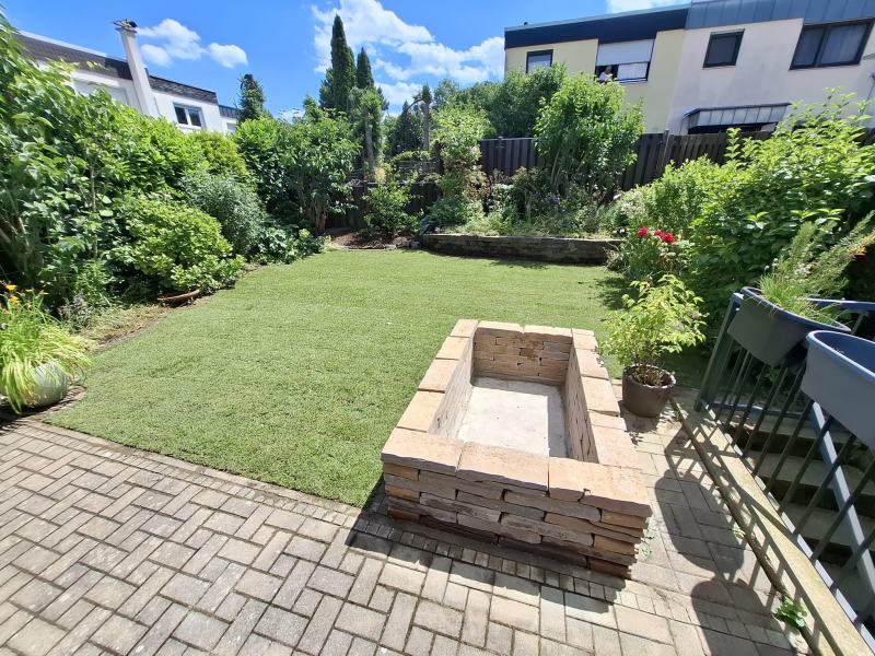 Fertiger Garten in Meckenheim: neuer Rollrasen und Hochbeet aus Naturstein neben der gepflasterten Terrasse